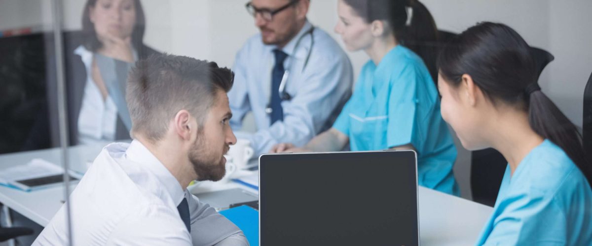 Doctors discussing over laptop in meeting at conference room